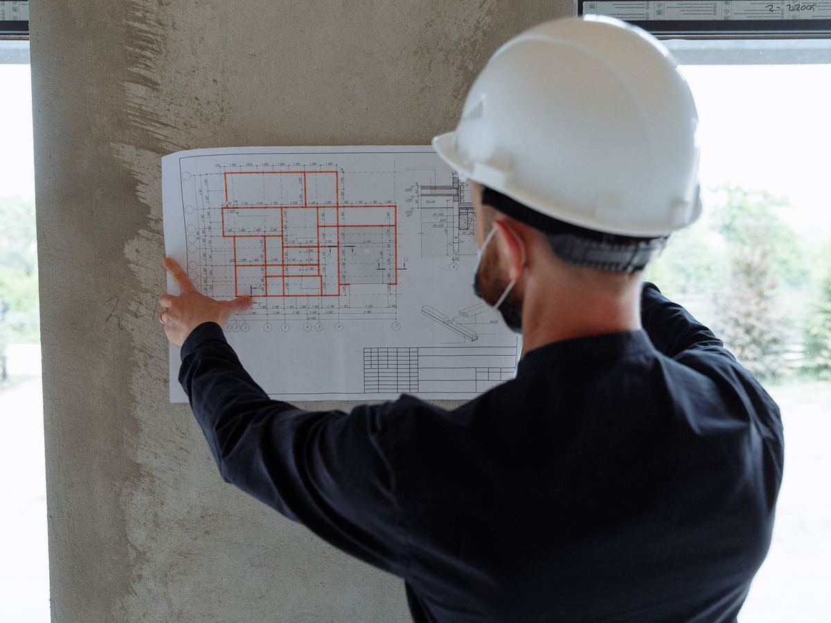Lecture des plans d'exécution sur le chantier, casque de sécurité
